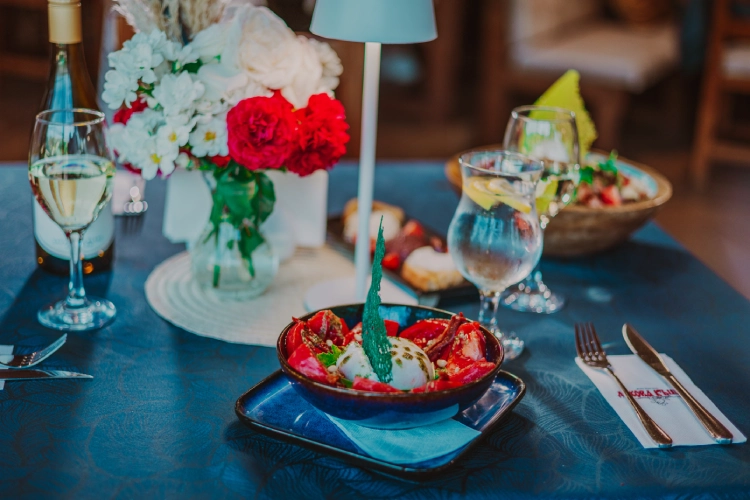Salată gourmet cu burrata, un pahar de vin alb și o masă elegantă la restaurantul Dukov, orașul Kavarna